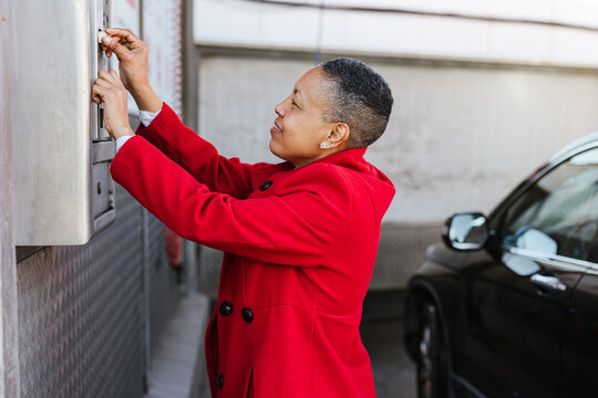 A woman inserts coins into the car wash