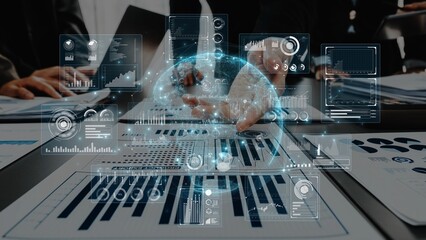 Two business professionals engaged in data analysis using a digital screen, showcasing interactive graphs and statistics to enhance decision-making processes. Raster