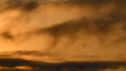 Dark brown and orange sunset stormy sky with fluffy clouds. Dramatic moody sky. Halloween cloudscape background concept.