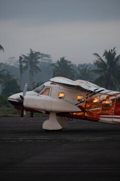 Twin-engine piston aircraft on tarmac at dawn