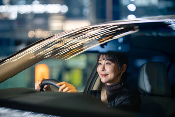 夜に車を運転する女性