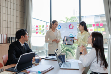 Employees presenting sales data during a business meeting.