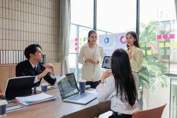 Employees presenting sales data during a business meeting.