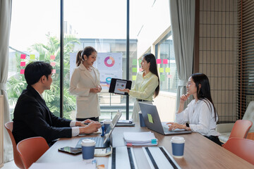 Employees presenting sales data during a business meeting.