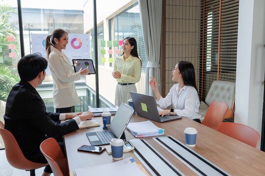 Employees presenting sales data during a business meeting.