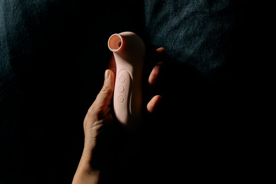 Hand holding a pink vibrator