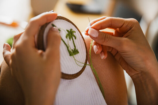 Close Up of Hand With Manicure Embroidery with Palm Tree Pattern