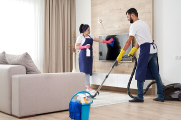 Professional cleaning service team cleans living room in modern apartment