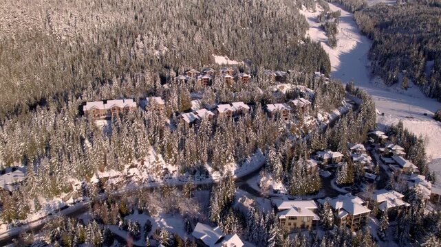 Alpine homes on hill at sunset, Whistler Mountain, aerial footage, winter scene, log cabin, luxury vacation home, mountain home. 4K 24FPS