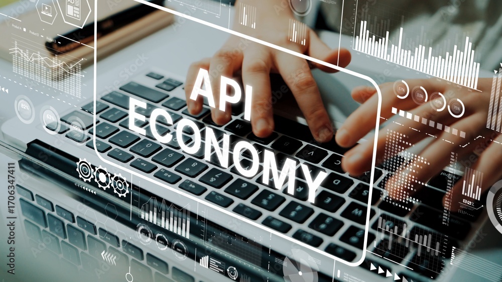 Poster hands typing on laptop keyboard with api economy text overlay and digital graphs in modern workspace