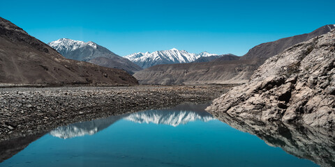 Majestic snow-capped Himalayan mountains near Leh under clear blue sky, showcasing stunning natural landscape, winter wilderness, breathtaking panoramic view of rugged peaks scenic tranquility