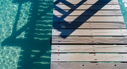 Obraz premium Wooden Pier With Rippling Water Shadows Tranquil Coastal Vacation Scene