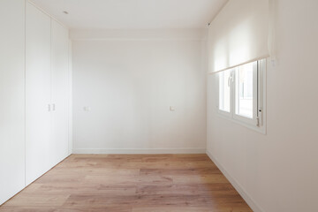 Bright bedroom with built-in wardrobe and wood flooring