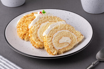 Delicious cake roll with creamy filling served on a speckled plate in a cozy kitchen setting