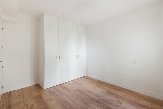 Bedroom corner with white built-in wardrobe