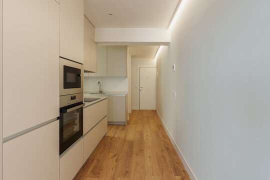 Long galley kitchen with oven and built-in cabinets
