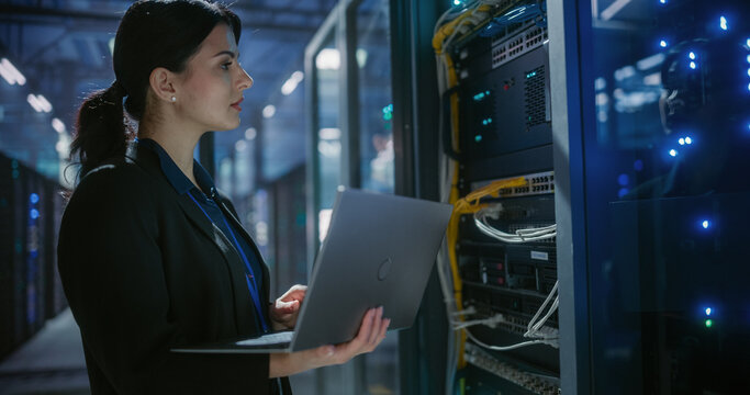 Engineer using laptop computer in data center.