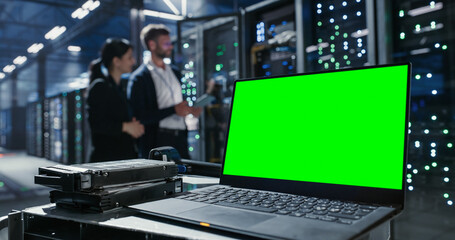 Laptop with green screen chroma key on the deks in data center.