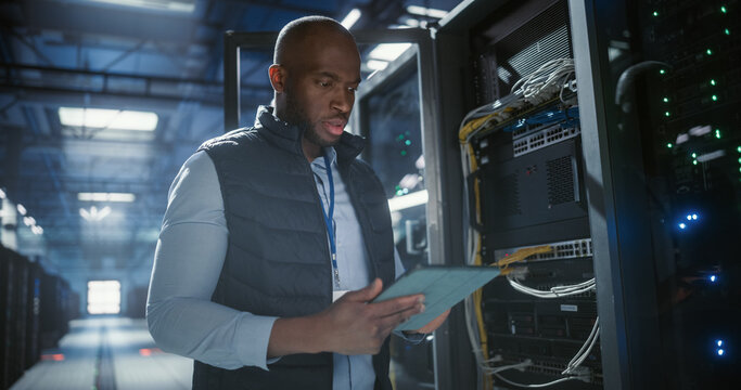 Data center technician inspects server racks, checks network cables. - Powered by Adobe