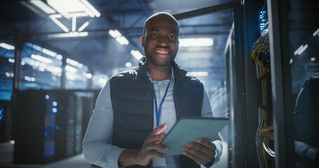 Portrait of technician inspecting server racks, checks network cables 