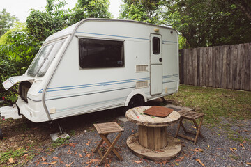 Peaceful outdoor camping site with vintage caravans parked under trees in natural setting, showcasing a serene travel lifestyle, relaxation, adventure, and sustainable eco-friendly tourism experience
