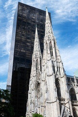 Side view of St. Patrick’s Cathedral in New York City, showcasing its neo-Gothic architecture amid the modern skyscrapers of Midtown Manhattan.