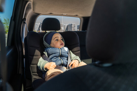 Child sitting in car seat looking forward