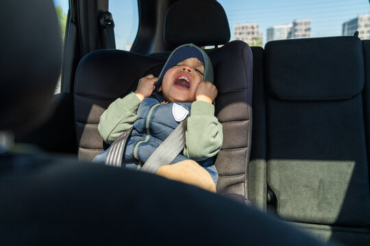 Crying child in car seat pulling hood

