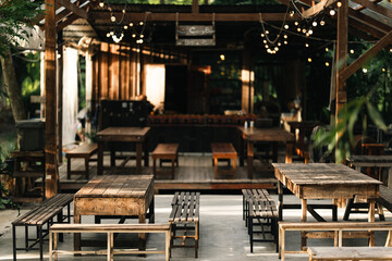 outdoor seating area with vintage wooden tables and benches under natural light, showcasing the charm of aged wood craftsmanship, peaceful atmosphere, sustainable design, and eco-friendly lifestyle