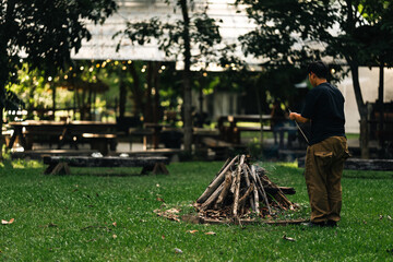 Campfire area surrounded by wooden benches and lush greenery in outdoor nature setting, perfect for group gathering, relaxation, eco-living, forest camping experience, and rustic open-air adventure