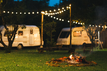 Peaceful outdoor camping site with vintage caravans parked under trees in natural setting, showcasing a serene travel lifestyle, relaxation, adventure, and sustainable eco-friendly tourism experience