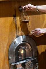 Visit of wine cellar with old large oak barrels, pouring of fortified dry or sweet tasty marsala wine from barrels in Marsala, Sicily, Italy