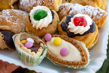 Italian sweet dessert dolce pastry and cakes with cream and fruits on plate made in artisanal bakery in Rome, Italy, close up