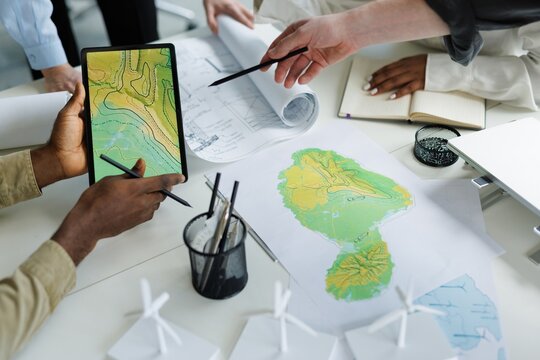 Partial of architect showing map on tablet for future windmill farm