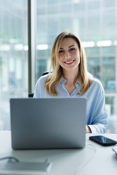 Portrait of happy company CEO looking at camera during working