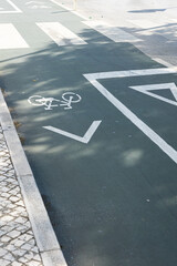 Close-up of a green bike lane with painted bicycle symbol and directional arrow, promoting urban mobility and sustainable transport.