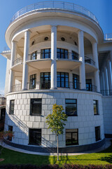 modern white building with blue sky and tiny tree nearby