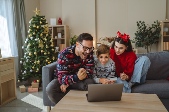 Family doing christmas online shopping using laptop and credit card