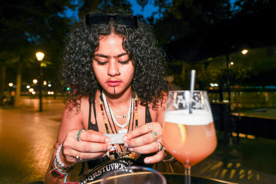  Preparing a joint and drinking at a bar at Night