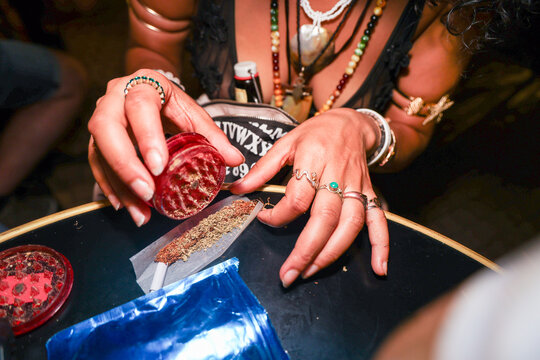 Person in close-up with flash light Preparing a joint in a Table