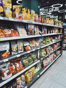 29.05.2025, Kuala Lumpur, Malaysia. Store aisle shelves filled with colorful Asian snack bags including dried fruit, beans, and seafood. Packaged Asian snacks, variety.