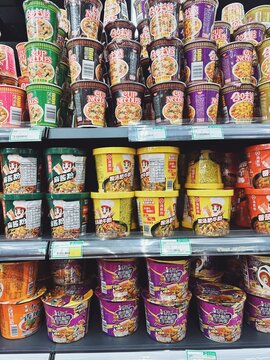 31.05.2025, Kuala Lumpur, Malaysia.Assortment of instant noodle cups stacked on supermarket shelves in colorful packaging. Multiple flavors and brands visible.
Instant food, Asian convenience meals.