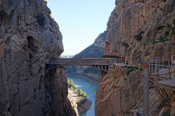 Breathtaking view of the Caminito del Rey walkway suspended between steep rocky cliffs over the El Chorro gorge and Guadalhorce river in Malaga, Spain