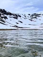 Obraz premium Stunning Landscape of Snow-Covered Mountains and Frozen Lake in Sierra Nevada, Spain - Scenic Winter View of Rugged Peaks and Icy Waters
