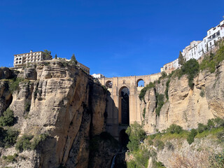 Puente Nuevo Bridge spanning the El Tajo gorge in Ronda, Spain under a clear blue sky, showcasing stunning historical architecture surrounded by dramatic cliffs and white buildings