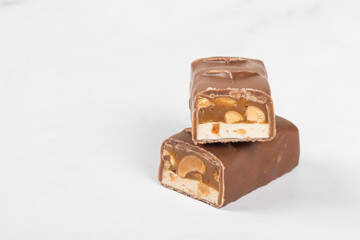 Chocolate bar. Nougat, caramel with peanuts, in chocolate. White background. Close up	