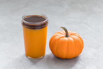 Halloween Pumpkin drink with coffee on top,  in a glass. Dark gray background. Close up