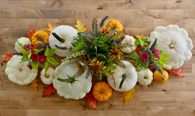 Autumn seasonal table centrepiece for harvest dinner using organic, natural elements gourds,...