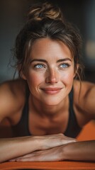 Fototapeta premium Beautiful young woman with blue eyes and freckles smiling on a yoga mat.
