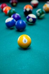 Billiard balls set up in starting position with cue stick approaching on green table